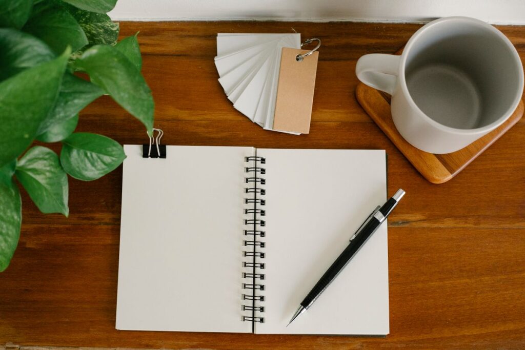 Blank notebook, pen, and coffee on a desk ready for deadline planning
