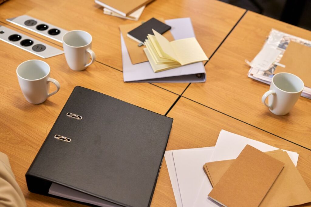 Organized document folders, a binder, and notes on a nonprofit office desk