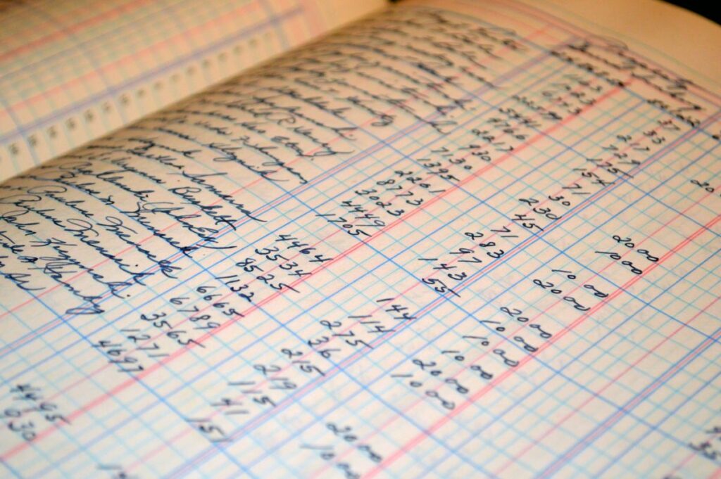 Close-up of a handwritten accounting ledger with columns of figures