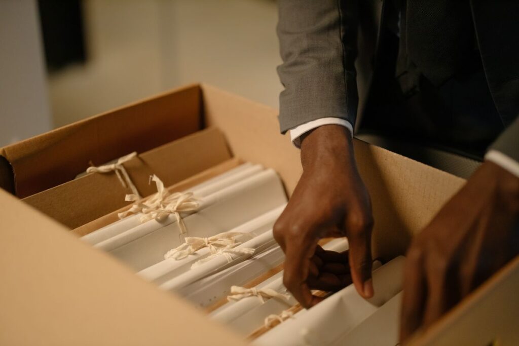 Person filing labeled household documents into a records box