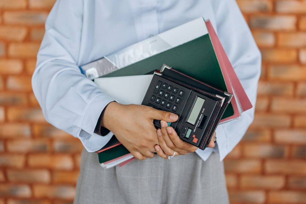 Professional holding organized financial folders and a calculator, representing tidy back-office records for a Madison, MS small business