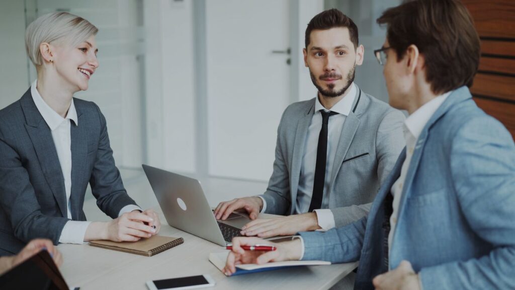 Business team meeting around a table with laptops and notebooks