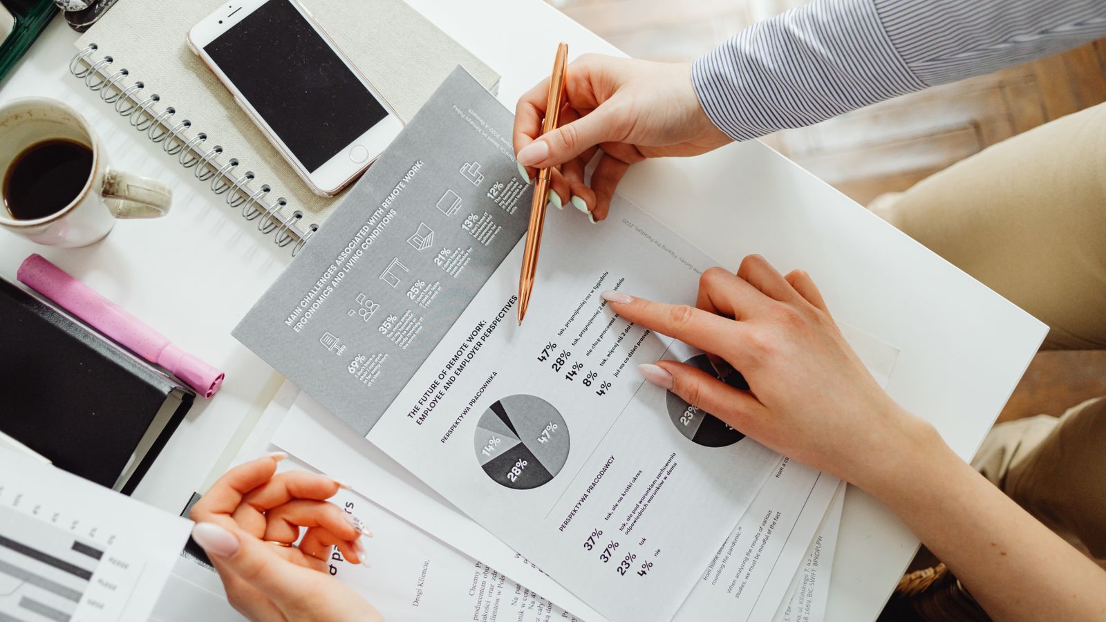 Small business owner and bookkeeper reviewing financial reports together to decide when to outsource bookkeeping