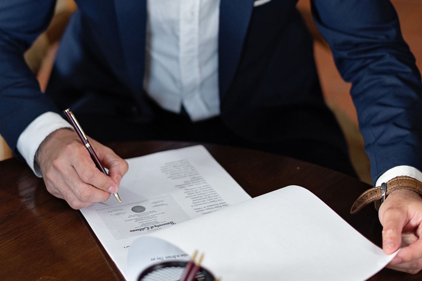 Business owner signing formation documents at an office desk in Mississippi