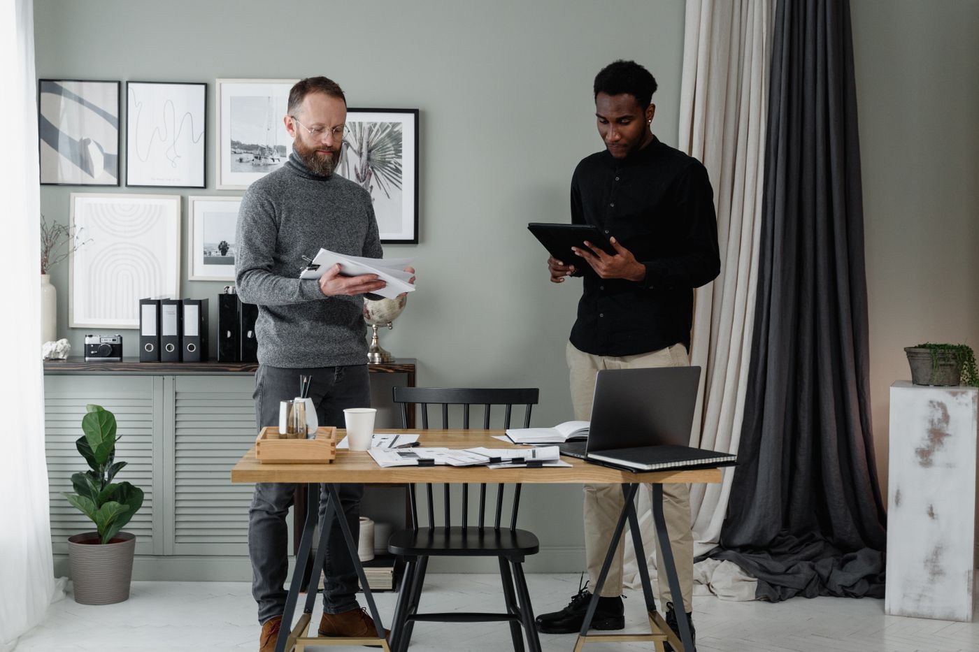 Two professionals reviewing documents in an office while setting up payroll for a first employee